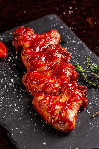 墨西哥食物的概念。木桌上的黑板上放着烤鸡翅和辣番茄沙司。的背景图片。本空间图片下载