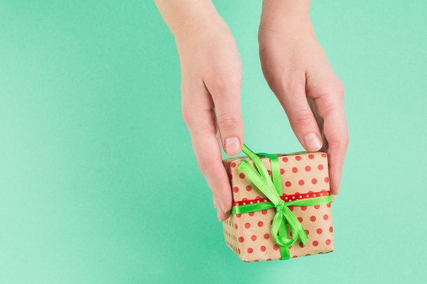 在绿色背景的女人手中呈现。图片下载