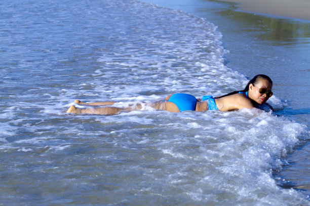 女人比基尼蓝色快乐放松与波在Ban Krut海滩，图片下载