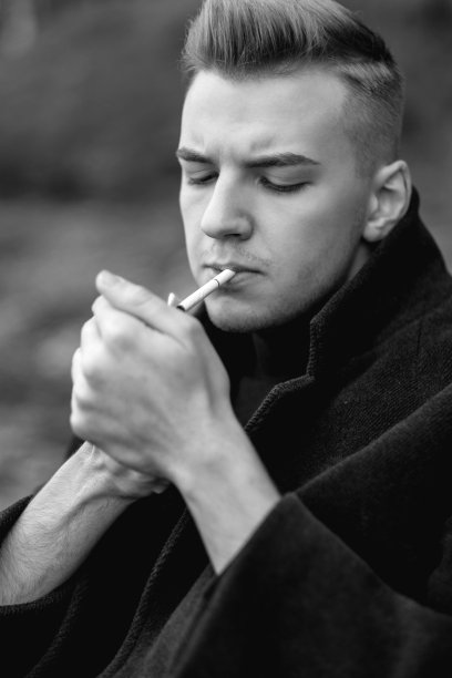 帅气的男人穿着外套抽着烟，艺术人像的男人，黑白照片图片下载