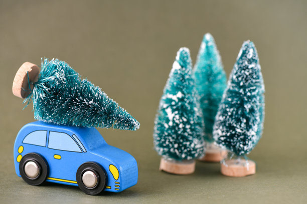 蓝色的玩具车，车顶有一棵圣诞树。高分辨率照片作为圣诞背景。图片下载