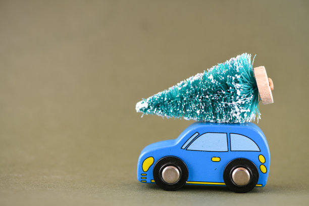 蓝色的玩具车，车顶有一棵圣诞树。高分辨率照片作为圣诞背景。图片下载