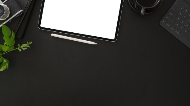顶视图黑暗时尚的工作场所模拟平板电脑和办公用品在黑暗的桌子上图片下载