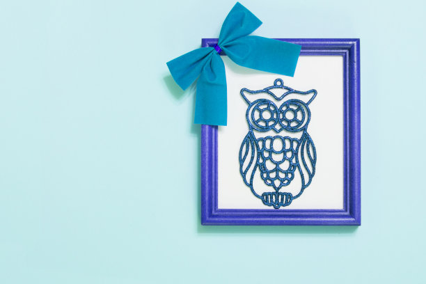 蓝色相框与猫头鹰和蝴蝶结在蓝色背景图片下载
