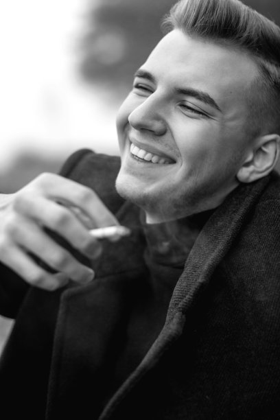 帅气的男人穿着外套抽着烟，艺术人像的男人，黑白照片图片下载