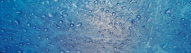 雨滴落在蓝色伞的表面。从下往上看。秋天的雨季。防水的概念。图片下载