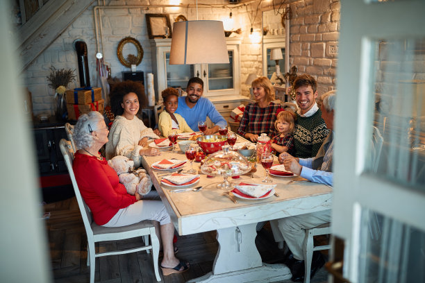 家人和快乐的朋友在家里吃圣诞晚餐图片下载