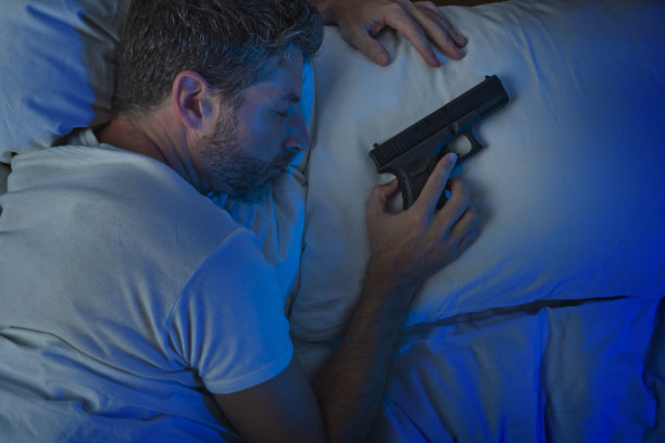 晚上的肖像年轻的压力和偏执的美国男人在床上睡觉和拿着枪害怕闯入家的多疑和自我防卫的概念图片下载