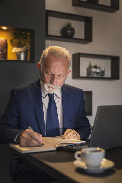 资深的商人正在做计划，写在计划表上图片下载