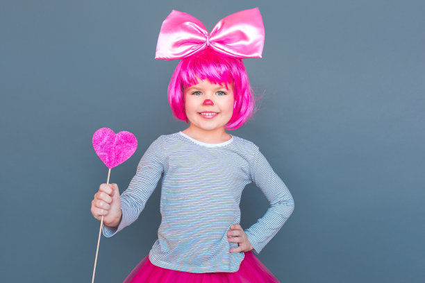 情人节快乐!女孩穿着粉红色的套装拿着心脏图片下载