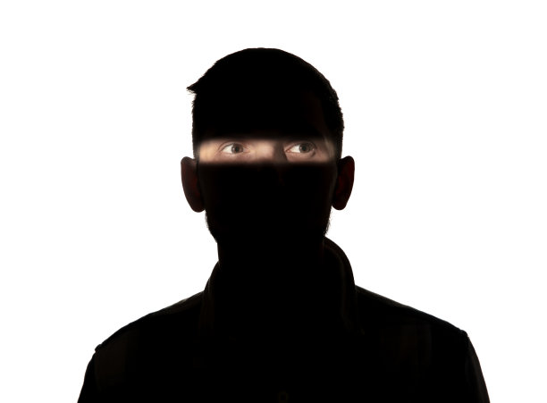 一个戏剧性的男人在黑暗中的肖像在白色的工作室背景。图片下载