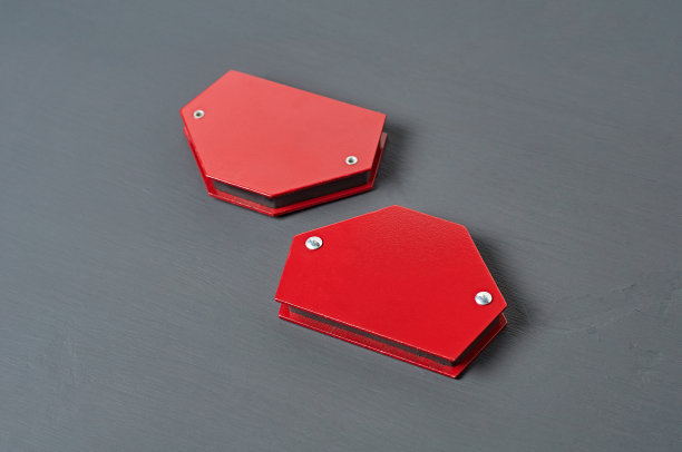 一对磁铁角固定金属细节焊接躺在车间的黑色混凝土桌子上。特写镜头图片下载