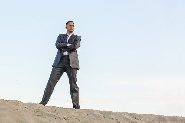 穿着优雅的英俊男子走在沙漠里图片下载