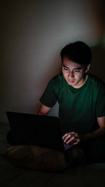 亚洲千禧一代晚上在卧室工作图片下载