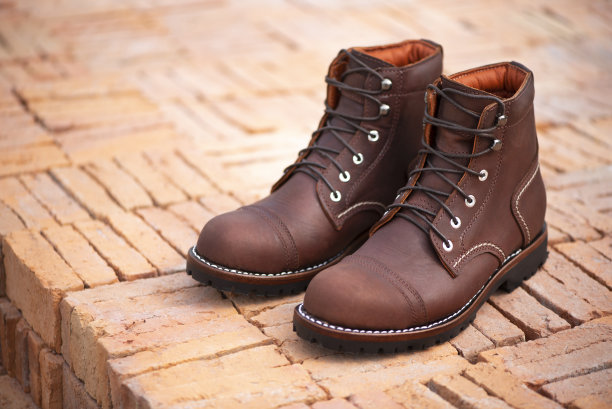 男时尚棕色靴子与真皮。时尚广告靴子照片上的砖背景。图片下载