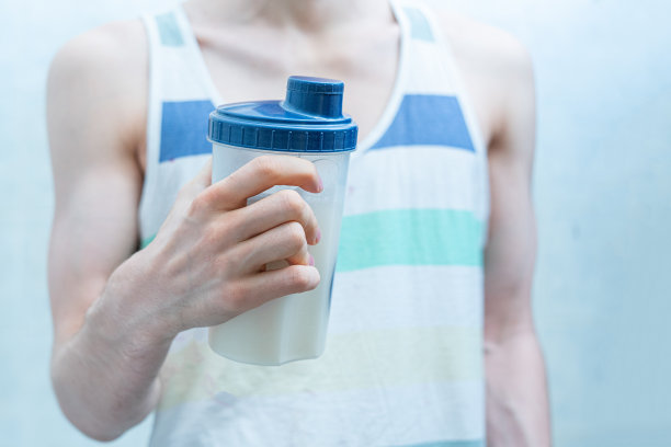 男性瘦骨嶙峋的运动男子在锻炼时拿着一个摇瓶图片下载