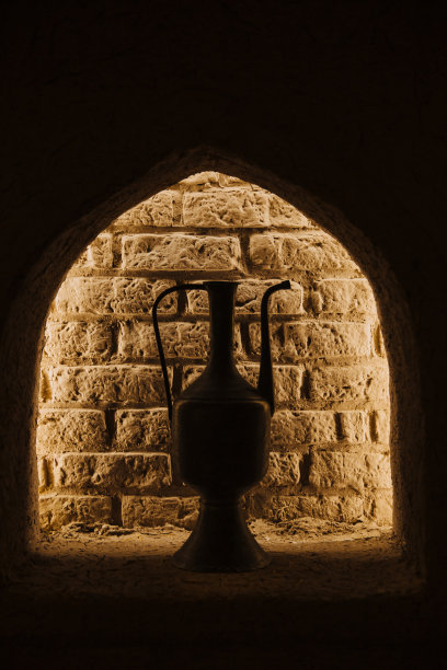 砖墙边立着一个古老的水壶图片下载