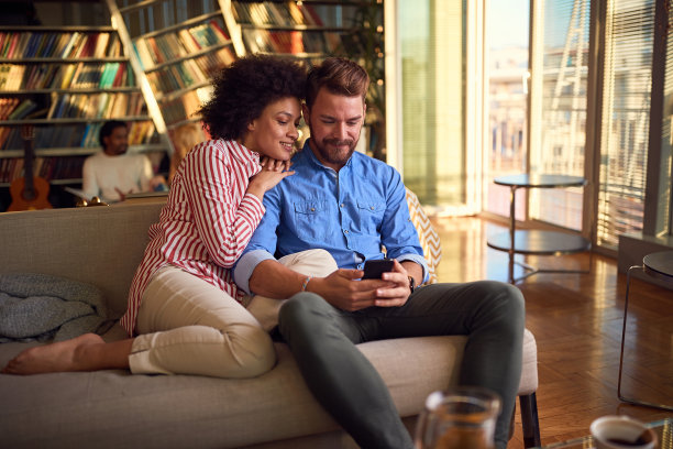 一对可爱的夫妇在一起玩智能手机图片下载