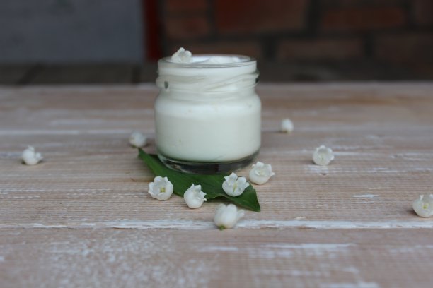 有机化妆品。木板的背景是奶油和铃兰图片下载