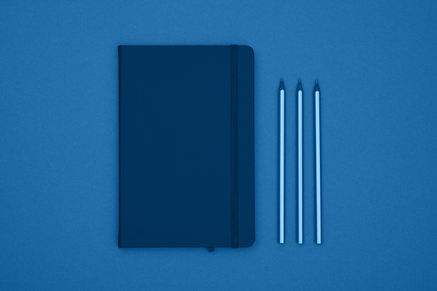 关闭皮革封面笔记本平铺在蓝色图片下载