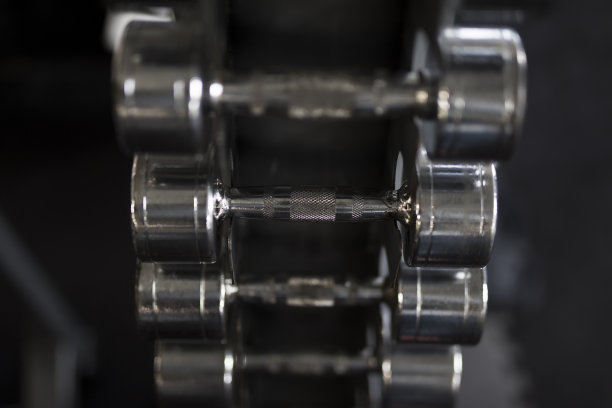 在体育馆架子上的一排金属哑铃图片下载