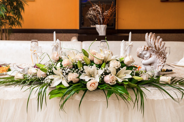 用鲜花装饰婚宴的桌子:奶油色的百合和玫瑰图片下载