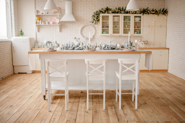 节日的冬季舒适的厨房室内花环，装饰和礼物。圣诞晚餐在装饰的桌子上。图片下载