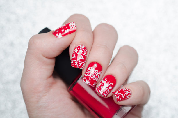 红色的圣诞美甲，点缀着鹿和雪花图片下载
