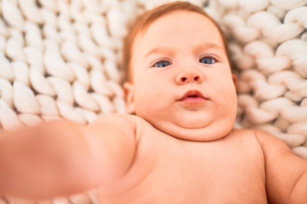可爱的宝宝躺在沙发上盖着毯子。新生儿放松和休息舒适图片下载
