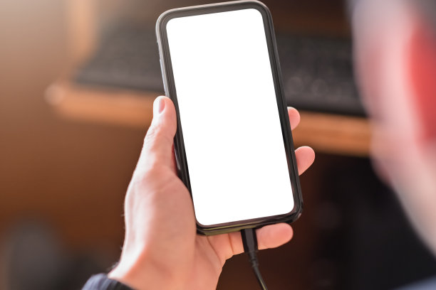 男子手持智能手机和使用设备和充电设备，同时使用的空白屏幕为原型图片下载