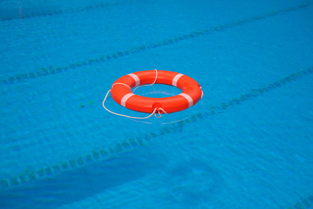 池水里有红色救生圈。蓝色水面有救生圈图片下载