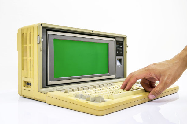 很旧的笔记本电脑在白色的背景和绿色的显示器屏幕上有手进入键盘图片下载