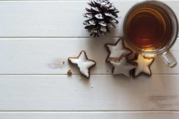 俯视图一杯茶，星形饼干和松果在白色木桌上。与复制空间图片下载
