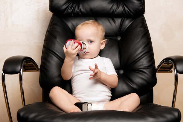 小女孩坐在办公椅上玩邮票图片下载