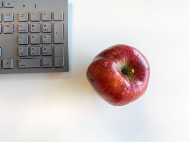 桌上放着红苹果和键盘图片下载