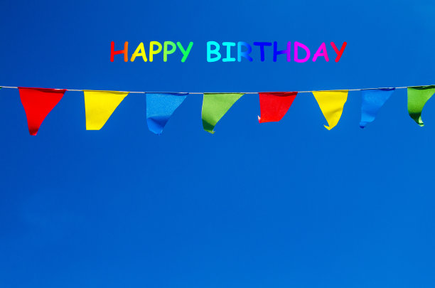 生日快乐彩旗在蓝天背景下。祝福生日贺卡图片下载