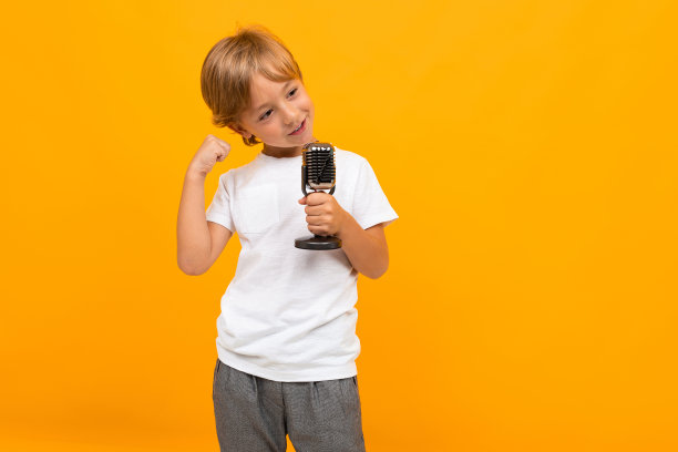 金发男孩，黄色背景，麦克风图片下载