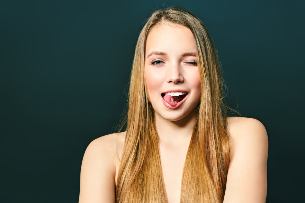 年轻的疯狂的女士。音乐爱好者摇滚迷的概念。近距离的照片肖像兴奋的funky滑稽滑稽的快乐的女士使stick tongue out标志孤立在一个黑色的背景图片下载