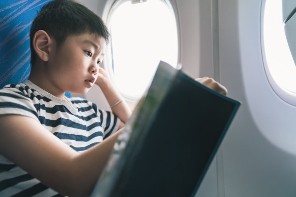 小男孩在飞机上看书图片下载