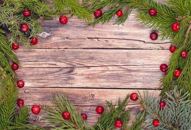圣诞贺卡。圣诞问候布局模板与冷杉树枝和红浆果。木制背景的圣诞卡。圣诞节的背景。圣诞节。新年快乐。副本的空间。图片下载