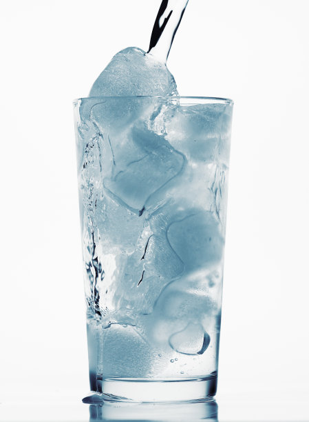 将水倒入装满冰块的玻璃杯中，白色背景，蓝色色调的物体图片下载