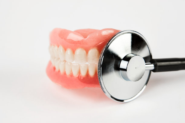 诊断、修复、治疗理念。假牙和放大镜图片下载