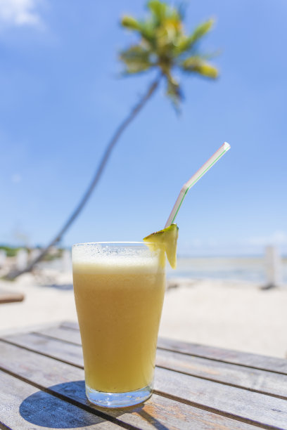 在海边的热带海滩上，一杯菠萝汁。旅游度假概念图片下载