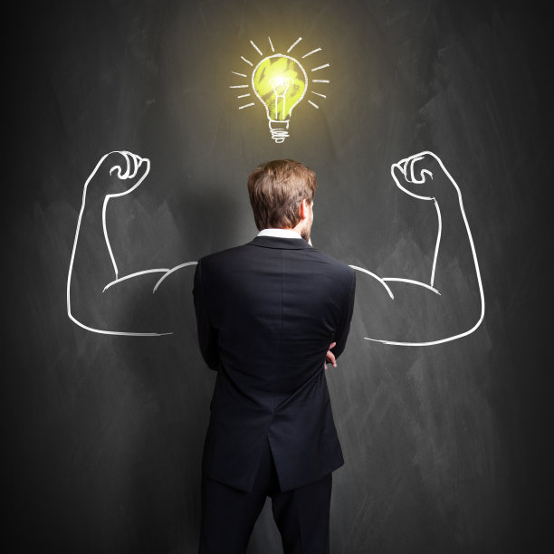 成功的商人站在黑板前画一个灯泡图片下载