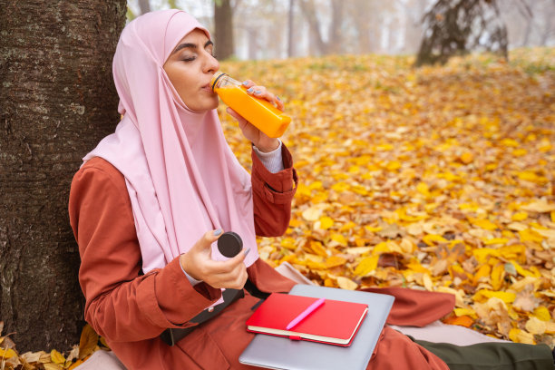 在秋日公园畅饮美味果汁（摄影图片）图片下载