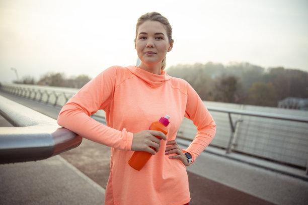微笑的运动女士站在桥上图片下载