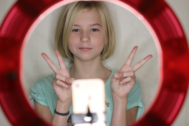 可爱的小博主女孩穿着薄荷色t恤在运河上为她的粉丝拍摄视频图片下载