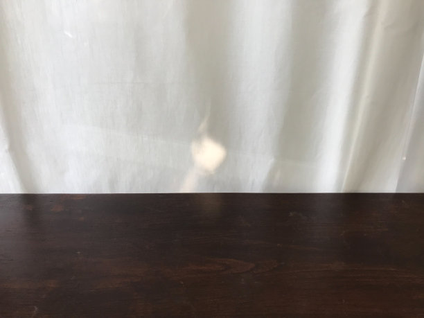 空的深棕色木桌在前景与白色棉花窗帘和阳光图片下载
