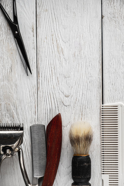 老式的理发工具，危险的剃须刀，理发剪刀，老式的手动剪，梳子，剃须刷。垂直图片下载