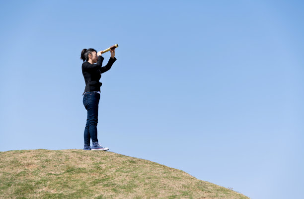 在山上透过望远镜看的女商人图片下载